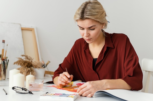 Mujer pintando con acuarelas sobre papel