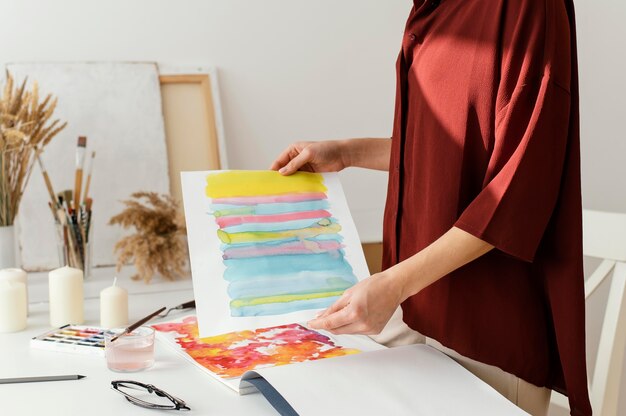 Mujer pintando con acuarelas sobre papel