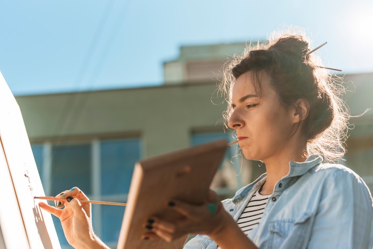 Foto gratuito mujer pintando al aire libre