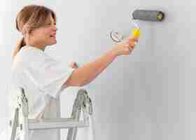 Foto gratuita mujer pintando la pared con rodillo