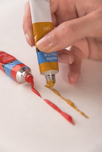 Mujer pintando con pintura de acuarela sobre papel blanco