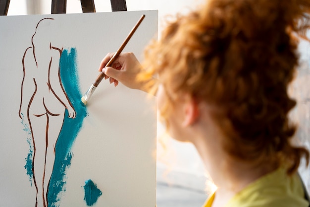 Mujer pintando sobre lienzo de cerca