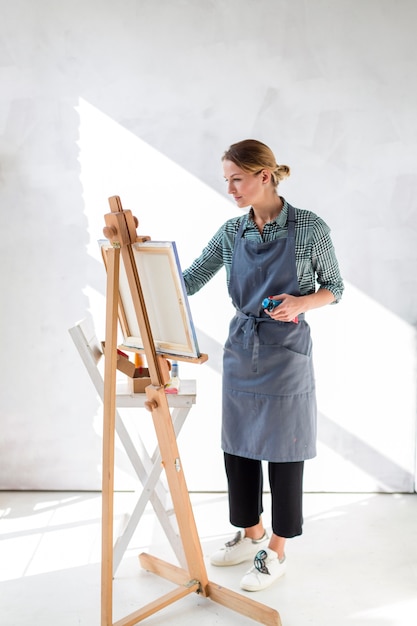 Mujer pintando sobre lienzo en estudio