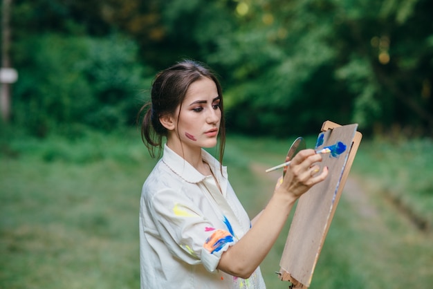 Mujer pintando sobre una superficie marrón