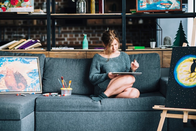 Mujer pintando en sofá