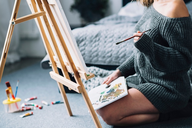 Mujer pintando en suelo de dormitorio