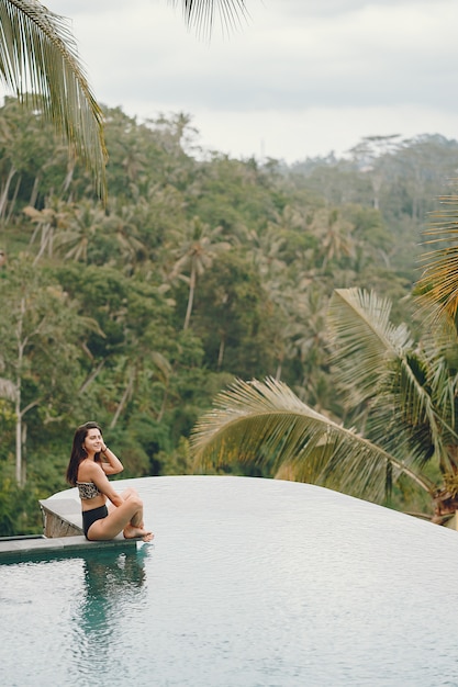 Mujer en una piscina en una vista de la selva