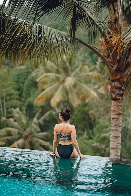 Mujer en una piscina en una vista de la selva