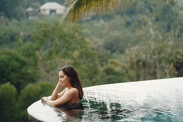 Mujer en una piscina en una vista de la selva