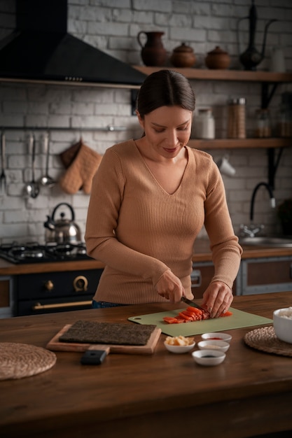 Mujer de plano medio aprendiendo a hacer sushi