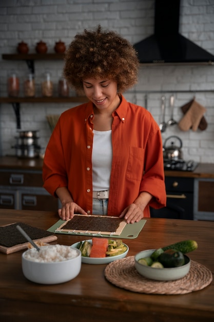 Mujer de plano medio aprendiendo a hacer sushi