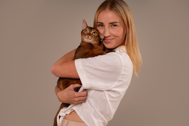 Foto gratuita mujer de plano medio con gato en estudio.