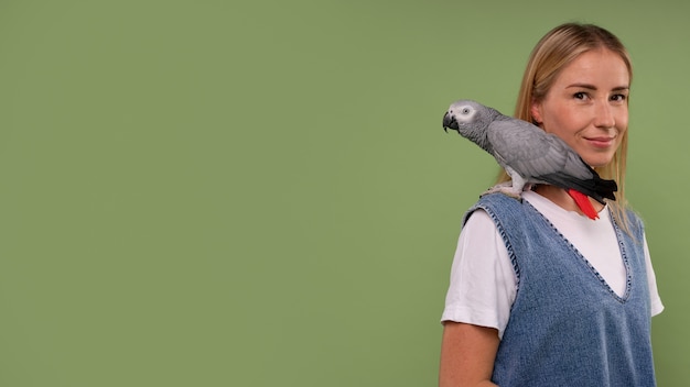 Foto gratuita mujer de plano medio con loro en estudio.