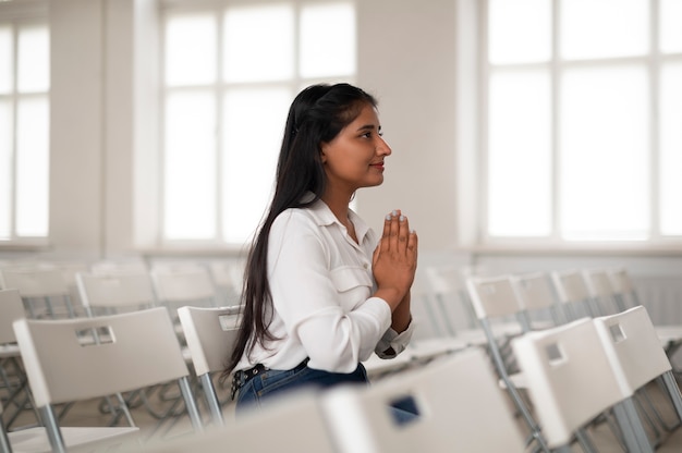 Mujer de plano medio orando en la iglesia