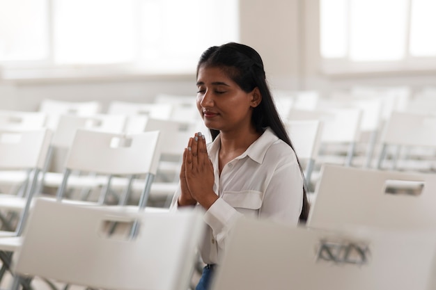 Foto gratuita mujer de plano medio orando en la iglesia