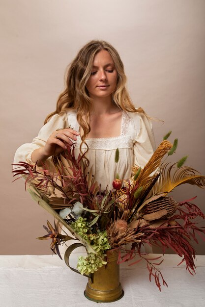 Foto gratuita mujer con plantas secas tiro medio