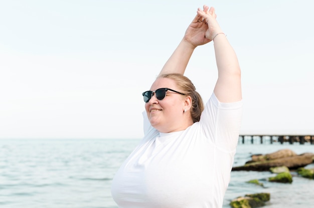 Mujer en la playa haciendo ejercicios de estiramiento