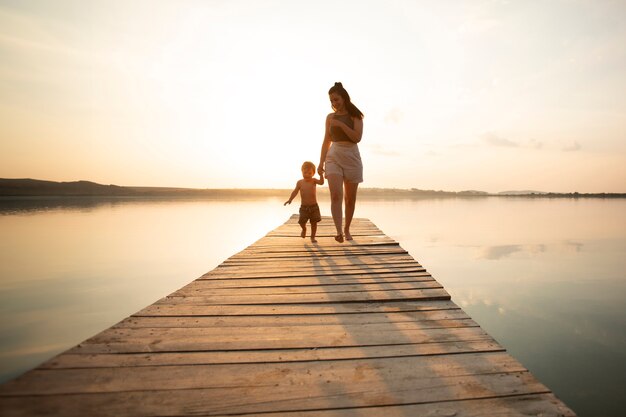 Mujer en la playa con su bebé disfrutando del atardecer