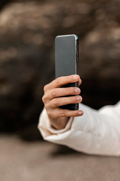 Mujer en la playa tomando fotografías con smartphone