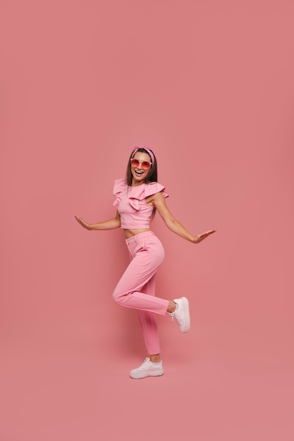 Una mujer en plena foto posando con un traje rosado