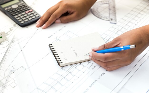 Mujer con pluma tomando notas cerca de plan