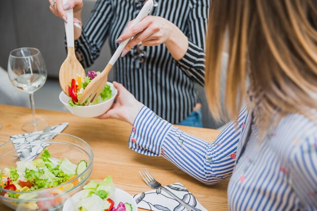 Mujer poniendo comida de dieta en un plato