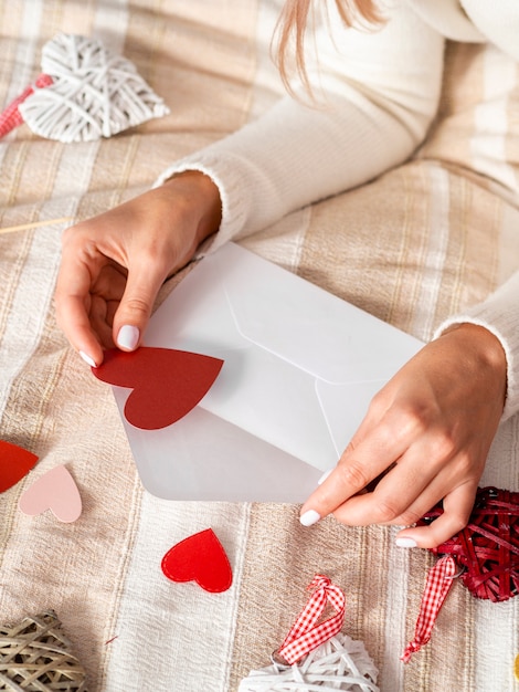 Mujer poniendo corazones en sobre