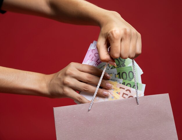 Mujer poniendo dinero en una bolsa de compras