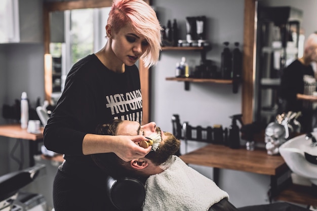 Mujer poniendo espuma en hombre con estilo