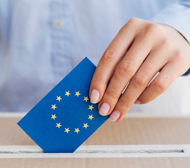 Mujer poniendo una papeleta europea en primer plano de la caja