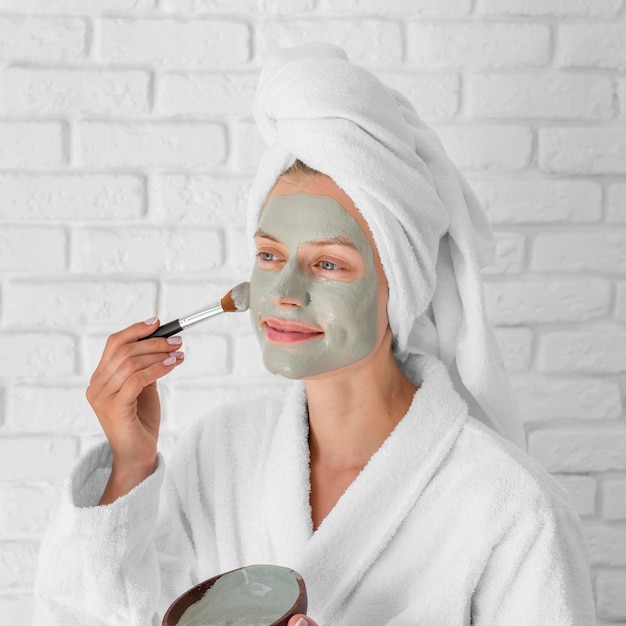 Foto gratuita mujer poniendo remedio facial tiro medio