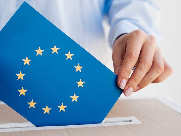 Mujer poniendo un sobre de la Unión Europea en una caja