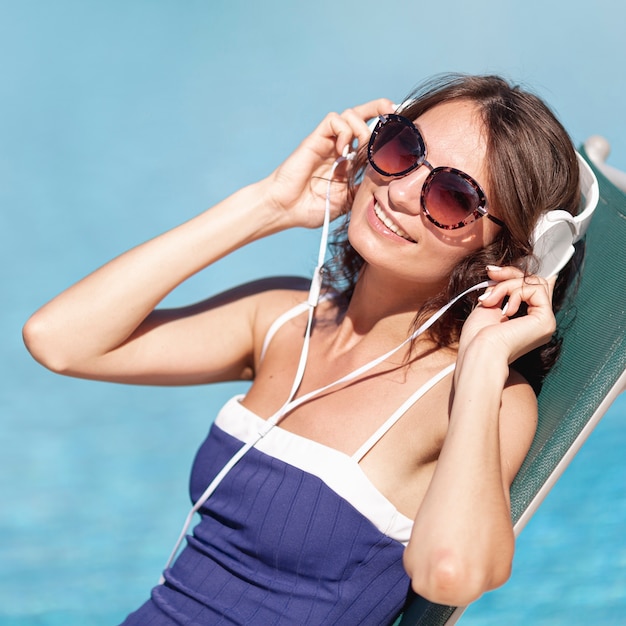 Mujer poniéndose los auriculares en salón