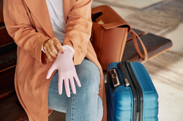 Mujer poniéndose guantes en el aeropuerto durante la pandemia