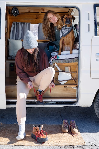 Mujer poniéndose los zapatos para emprender una aventura de invierno