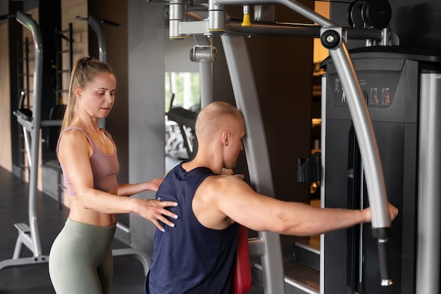 Foto gratuita mujer, porción, hombre, en, gimnasio, vista lateral