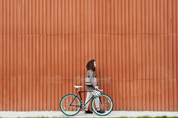 Mujer posando al aire libre con bicicleta