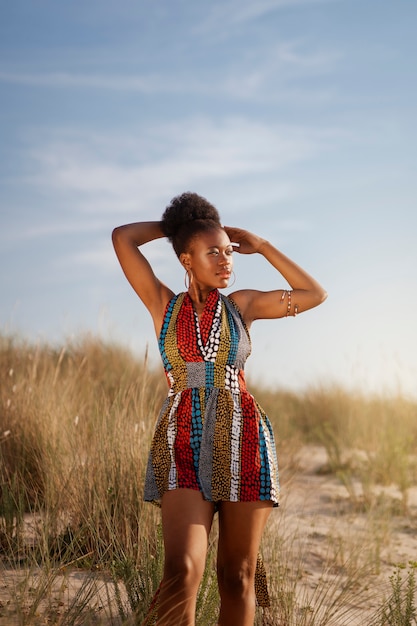 Foto gratuita mujer posando en un ambiente árido mientras usa ropa africana nativa