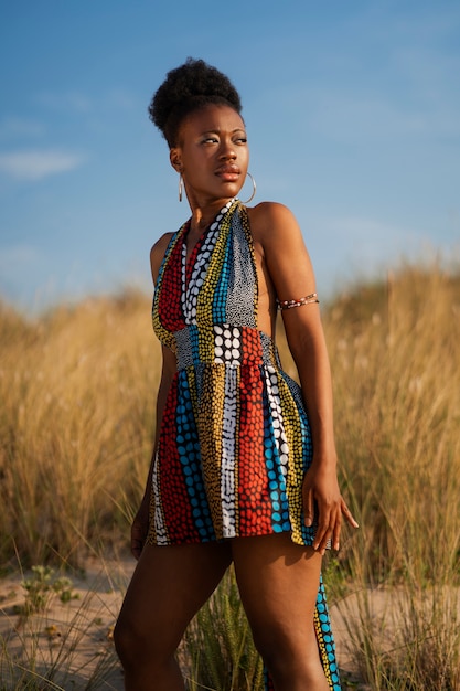 Foto gratuita mujer posando en un ambiente árido mientras usa ropa africana nativa