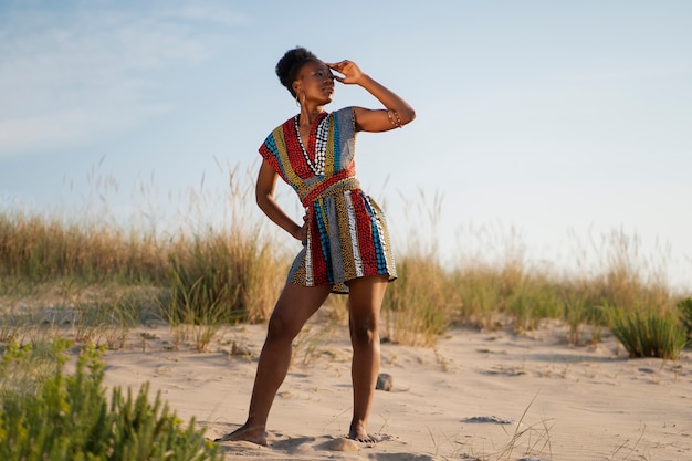 Foto gratuita mujer posando en un ambiente árido mientras usa ropa africana nativa