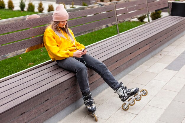 Mujer posando en un banco mientras usa patines