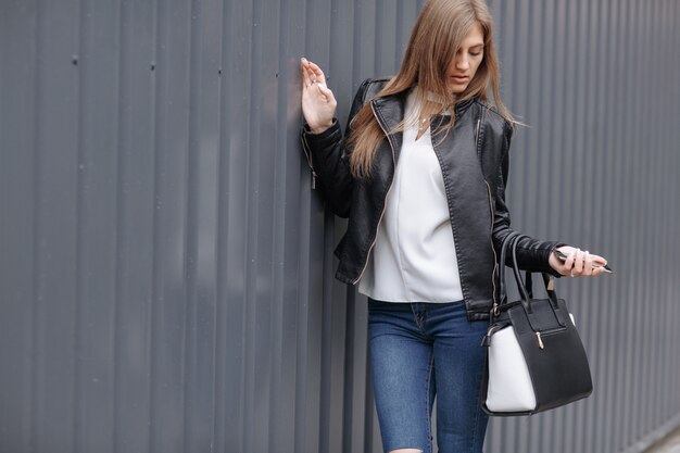 Mujer posando con bolsas de la compra en una mano