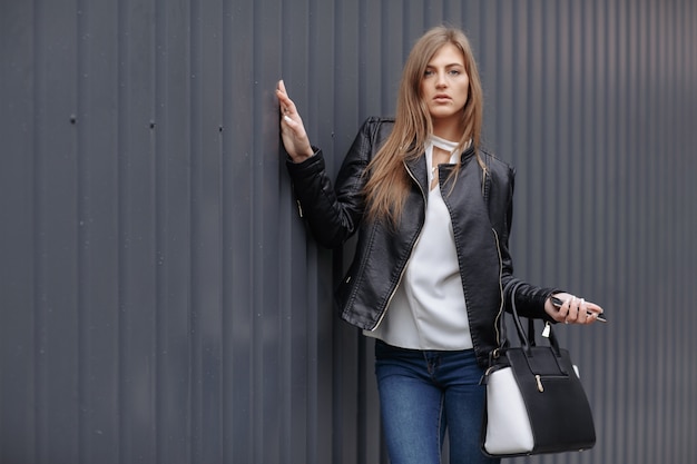 Mujer posando con un bolso negro y blanco