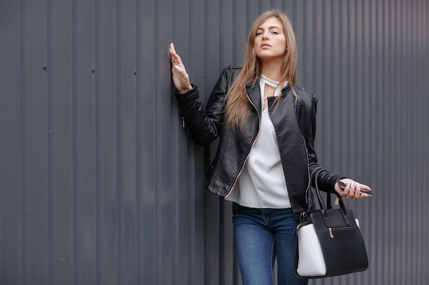 Mujer posando con un bolso negro y blanco