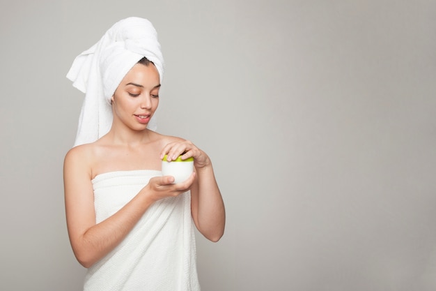 Mujer posando con crema cosmética