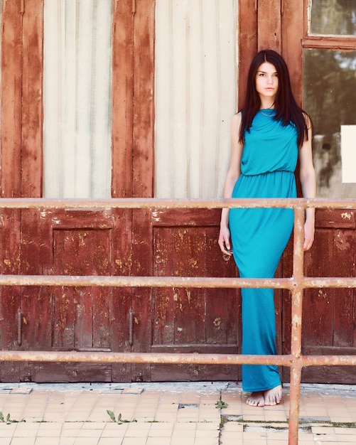 Mujer posando delante de una fachada de madera