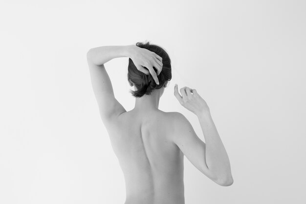 Mujer posando desnudez en blanco y negro vista posterior