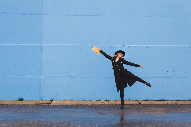 Mujer posando enfrente de un muro azul