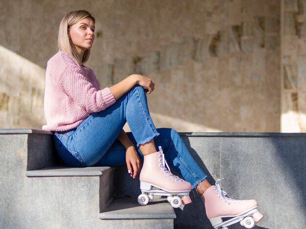 Mujer posando en las escaleras en jeans y patines
