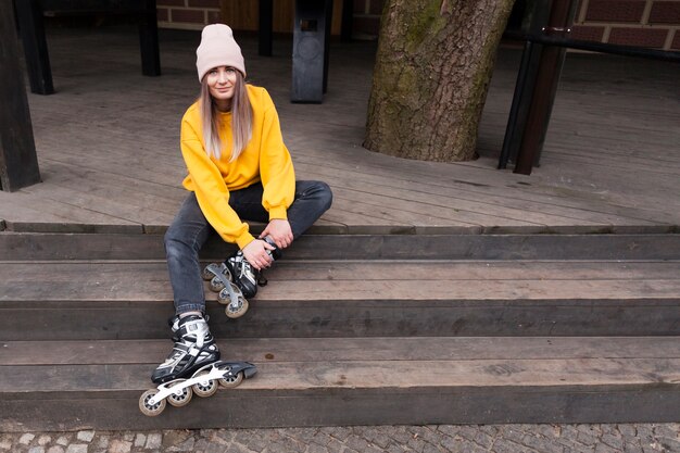 Mujer posando felizmente con patines en las escaleras